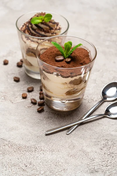 Classic tiramisu dessert in a glass cup on concrete background — Stock Photo, Image