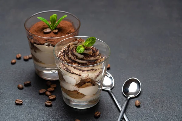 Postre tiramisú clásico en una taza de vidrio sobre fondo de hormigón oscuro —  Fotos de Stock