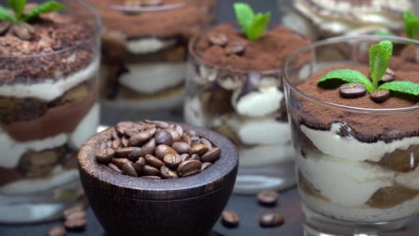 Gruppo di porzioni di dessert tiramisù classico in una tazza di vetro su tavola di pietra su sfondo di cemento — Video Stock