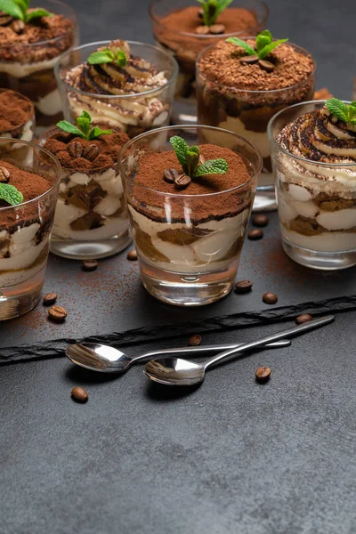 Group of portions of Classic tiramisu dessert in a glass cup on stone board on concrete background — Stock Photo, Image