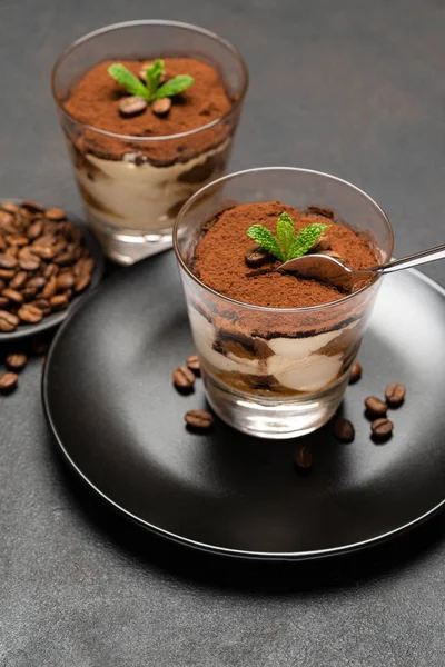 Portion klassisches Tiramisu-Dessert in einer Glasschale auf dunklem Betongrund — Stockfoto