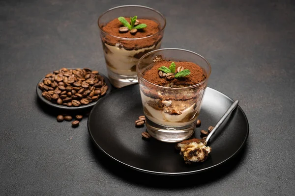 Portion klassisches Tiramisu-Dessert in einer Glasschale auf dunklem Betongrund — Stockfoto