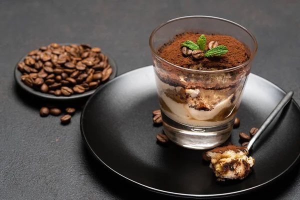 Porção de sobremesa tiramisu clássico em uma xícara de vidro no fundo de concreto escuro — Fotografia de Stock