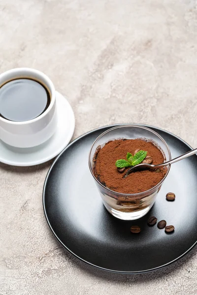 Portie klassiek Tiramisu dessert in een glazen beker en espresso koffie op concrete achtergrond — Stockfoto