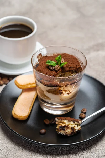 Klasik tiramisu tatlısı bir cam fincan ve beton arka plan üzerinde espresso kahve bölümü — Stok fotoğraf
