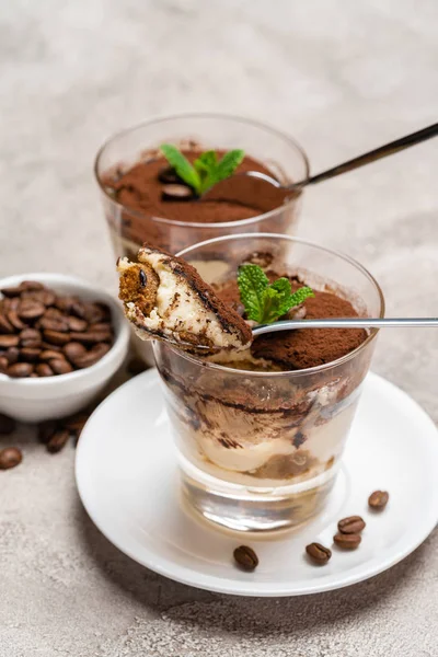 Portion of Classic tiramisu dessert in a glass cup on concrete background — Stock Photo, Image