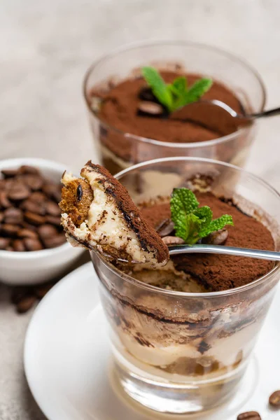 Portion of Classic tiramisu dessert in a glass cup on concrete background — Stock Photo, Image