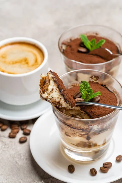 Чашка классического десерта тирамису в стакане и чашка кофе на бетонном фоне — стоковое фото