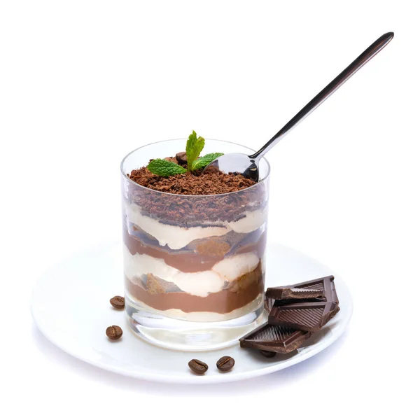Sobremesa tiramisu clássico em uma xícara de vidro na placa e pedaços de chocolate no fundo branco com caminho de recorte — Fotografia de Stock