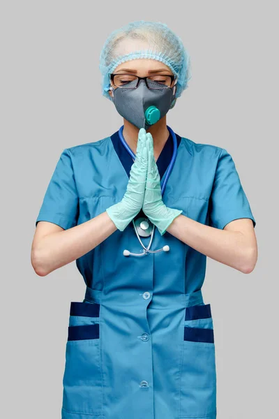 보호용 마스크를 쓰고 라텍스 장갑을 끼고 있는 의사 간호사 - 몸짓을 바라며 기도하는 나트 — 스톡 사진