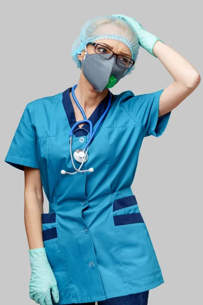 带听诊器的女医生，戴着防护面罩和乳胶手套，罩在浅灰的背景上 — 图库照片