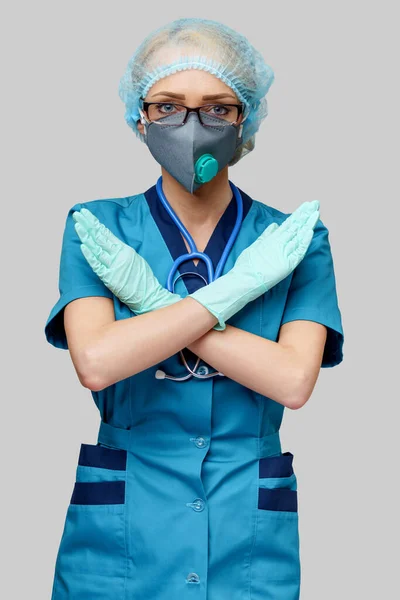 Médico feminino com estetoscópio vestindo máscara protetora e luvas de látex sobre fundo cinza claro — Fotografia de Stock