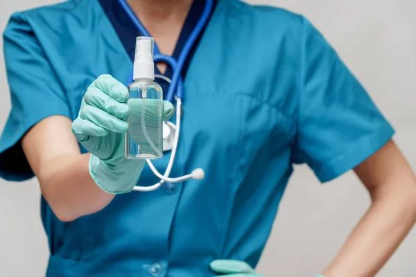 Orvos nővér visel védő maszk - gazdaság palack fertőtlenítő spray vagy gél — Stock Fotó