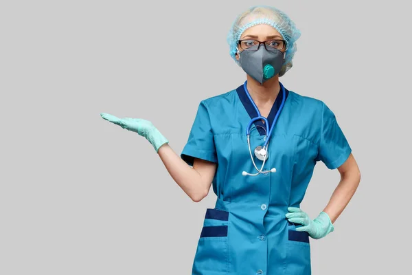 Femme médecin avec stéthoscope portant un masque protecteur et des gants en latex sur fond gris clair — Photo