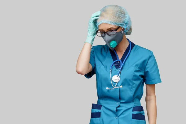 Femme médecin avec stéthoscope portant un masque protecteur et des gants en latex sur fond gris clair — Photo