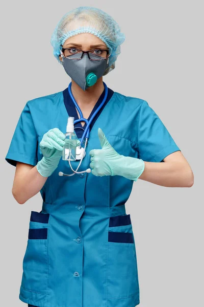 Medicinsk doktor sjuksköterska bär skyddande mask - innehÃ ¥llande flaska med saneringsspray eller gel — Stockfoto