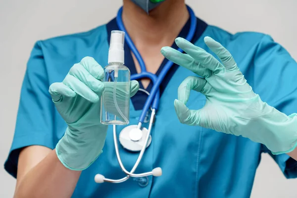 Enfermera médica que usa mascarilla protectora - sosteniendo una botella de aerosol o gel desinfectante —  Fotos de Stock