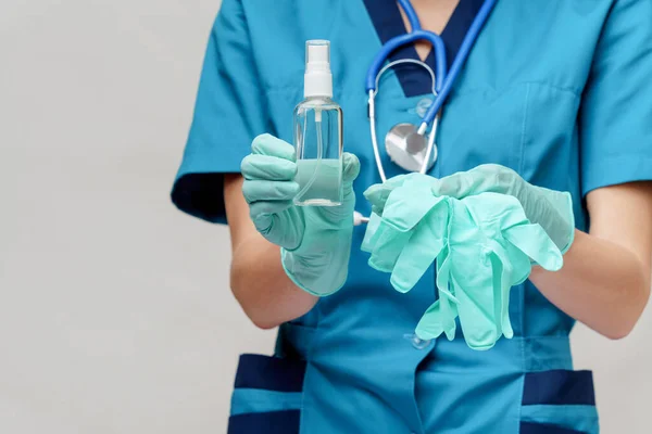 Enfermeira médica usando máscara protetora - segurando frasco de spray de higienização ou gel — Fotografia de Stock