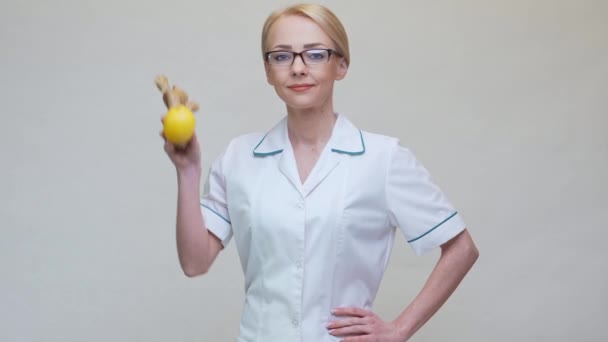 Nutritionist doctor healthy lifestyle concept - holding ginger root and lemon fruit — Stock Video