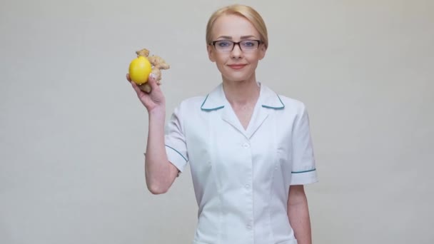 Nutritionniste médecin mode de vie sain concept - tenant racine de gingembre, fruit de citron et ruban à mesurer — Video