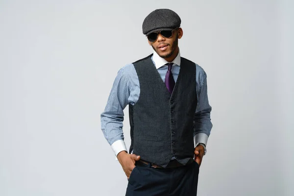Afroamerikaner mit Mütze, Hemd und Krawatte auf grauem Hintergrund — Stockfoto