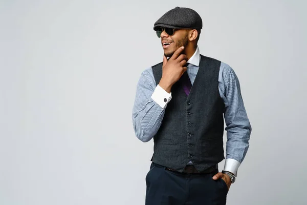 Homem afro-americano vestindo boné, camisa e gravata retrato sobre fundo cinza — Fotografia de Stock