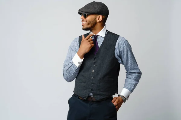 Homem afro-americano vestindo boné, camisa e gravata retrato sobre fundo cinza — Fotografia de Stock