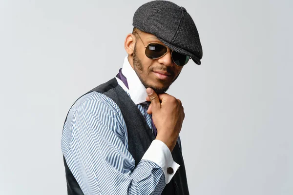 Uomo afro-americano che indossa cappello, camicia e cravatta ritratto su sfondo grigio — Foto Stock