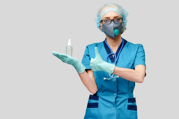 Medische arts verpleegkundige dragen beschermende masker - Holding fles van ontsmetten spray of gel — Stockfoto