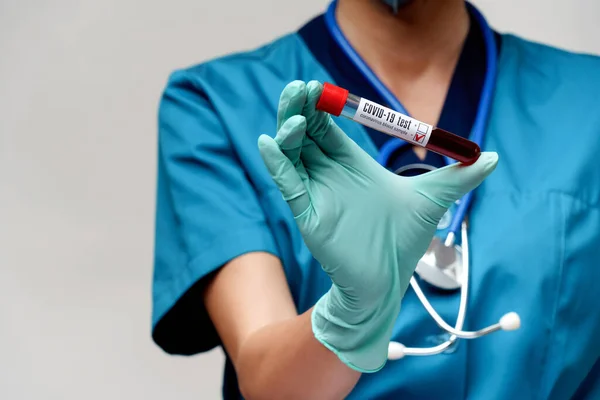 Médico enfermeira mulher usando máscara protetora e luvas - segurando coronavírus negativo COVID-19 teste de sangue — Fotografia de Stock