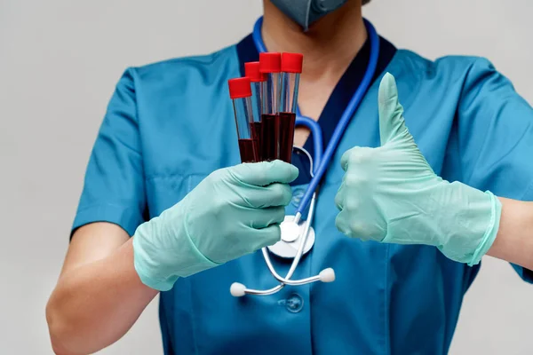 Médico enfermeira mulher usando máscara protetora e luvas - segurando vírus tubo de teste de sangue — Fotografia de Stock