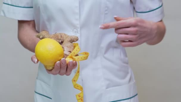 Nutricionista médico conceito de estilo de vida saudável - segurando raiz de gengibre, frutas de limão e fita métrica — Vídeo de Stock