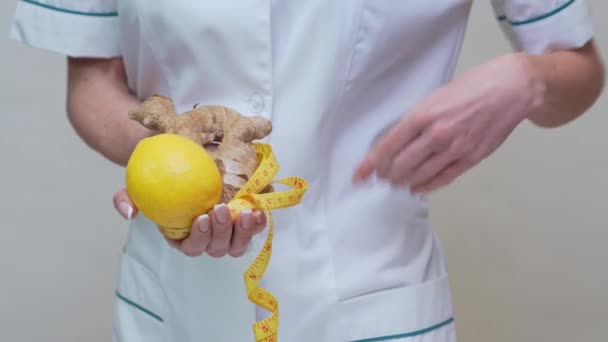 Nutriční lékař zdravý životní styl koncept - držení zázvorového kořene, citronového ovoce a měřicí pásky — Stock video