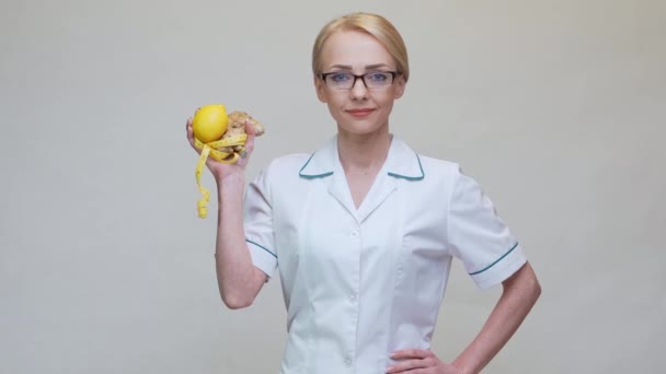 Nutritionist läkare hälsosam livsstil koncept - hålla ingefära rot, citron frukt och måttband — Stockvideo