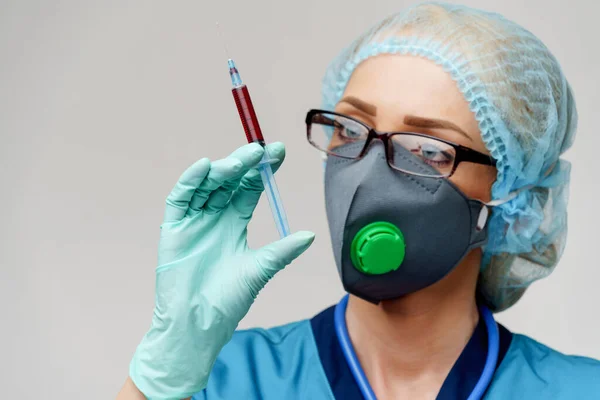 Médico enfermera mujer con máscara protectora y guantes - la celebración de la jeringa —  Fotos de Stock