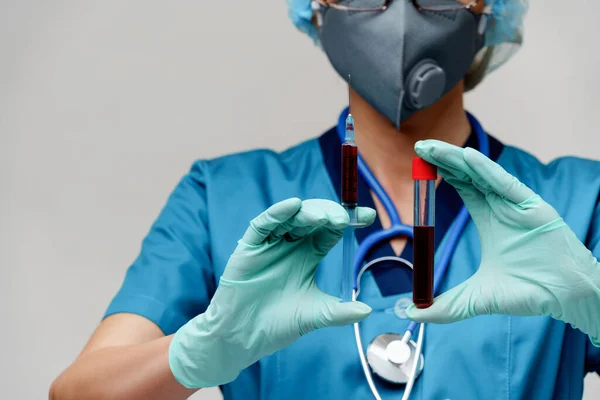 Verpleegkundige vrouw met beschermend masker en handschoenen - met virusreageerbuis en spuit — Stockfoto