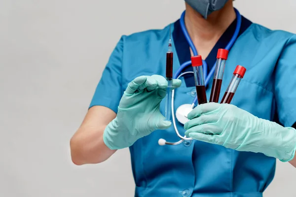 Врач медсестра женщина в защитной маске и перчатках - проведение пробирки крови вируса и шприц — стоковое фото