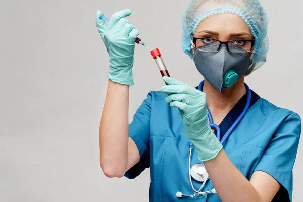 Verpleegkundige vrouw met beschermend masker en handschoenen - met virusreageerbuis en spuit — Stockfoto