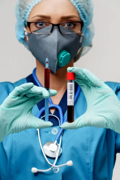 Verpleegkundige vrouw met beschermend masker en handschoenen - met virusreageerbuis en spuit — Stockfoto