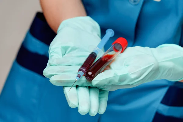 Médico enfermeira mulher usando máscara protetora e luvas - segurando vírus tubo de teste de sangue e seringa — Fotografia de Stock