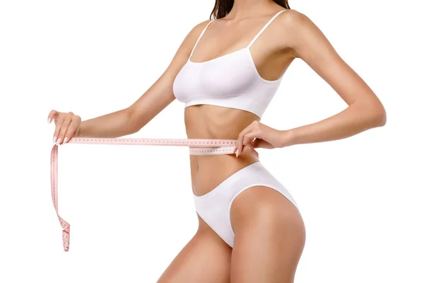 Slim tanned womans body over gray background - waist measurement — Stock Photo, Image
