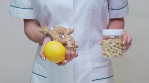 Nutritionniste médecin mode de vie sain concept tenant racine de gingembre, citron et vitamines pilules — Video