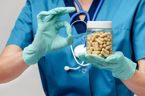 Ärztin Krankenschwester mit Schutzmaske und Gummi- oder Latexhandschuhen - Tabletten halten — Stockfoto