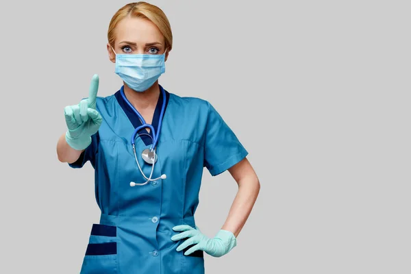 Verpleegkundige vrouw met stethoscoop met beschermend masker en rubber of latex handschoenen — Stockfoto