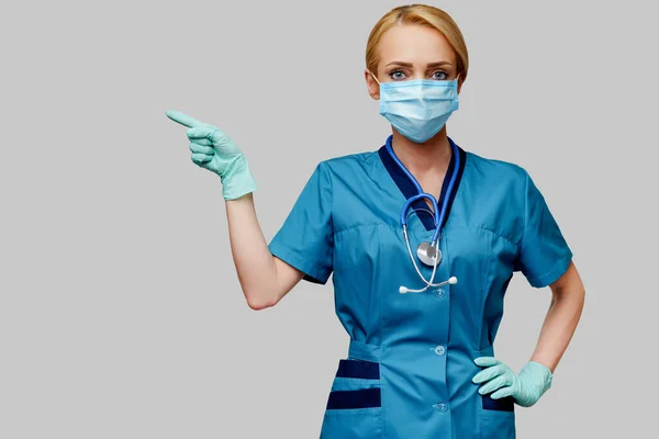 Γιατρός νοσοκόμα γυναίκα με στηθοσκόπιο φορώντας προστατευτική μάσκα και λαστιχένια ή λατέξ γάντια — Φωτογραφία Αρχείου