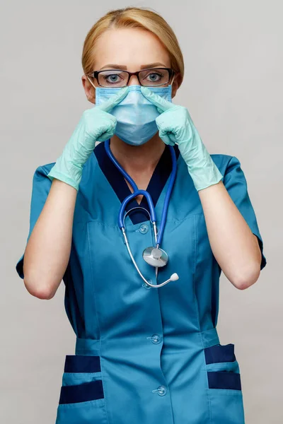 Médico enfermeira mulher com estetoscópio usando máscara protetora e luvas de borracha ou látex — Fotografia de Stock