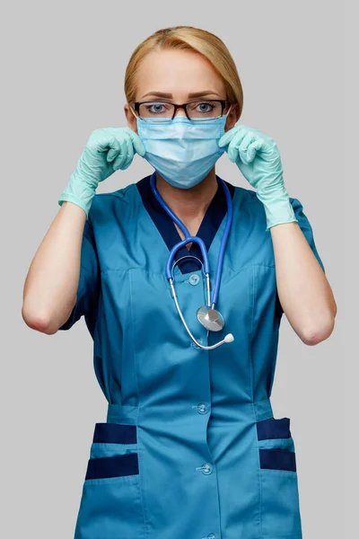 Medical doctor nurse woman with stethoscope wearing protective mask and rubber or latex gloves — Stock Photo, Image