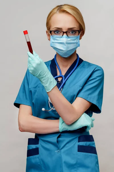 Medische arts verpleegkundige vrouw met beschermende masker en handschoenen - houden virus bloed reageerbuis — Stockfoto