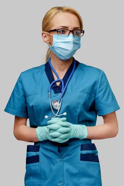 Медичний лікар медсестра жінка зі стетоскопом в захисній масці і гумі або латексних рукавичках — стокове фото