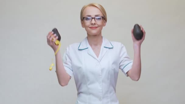 Konsep gaya hidup sehat dokter gizi memegang buah alpukat organik dan pita pengukur — Stok Video